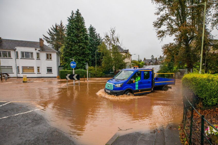 Council lorry going through deep water at a roundabout in the Craigie area of Perth