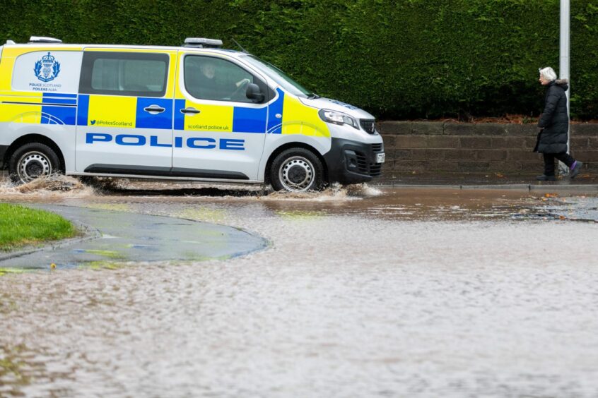 A police vehicle attempts to drive through flooding at Kinloss Park in Cupar. 