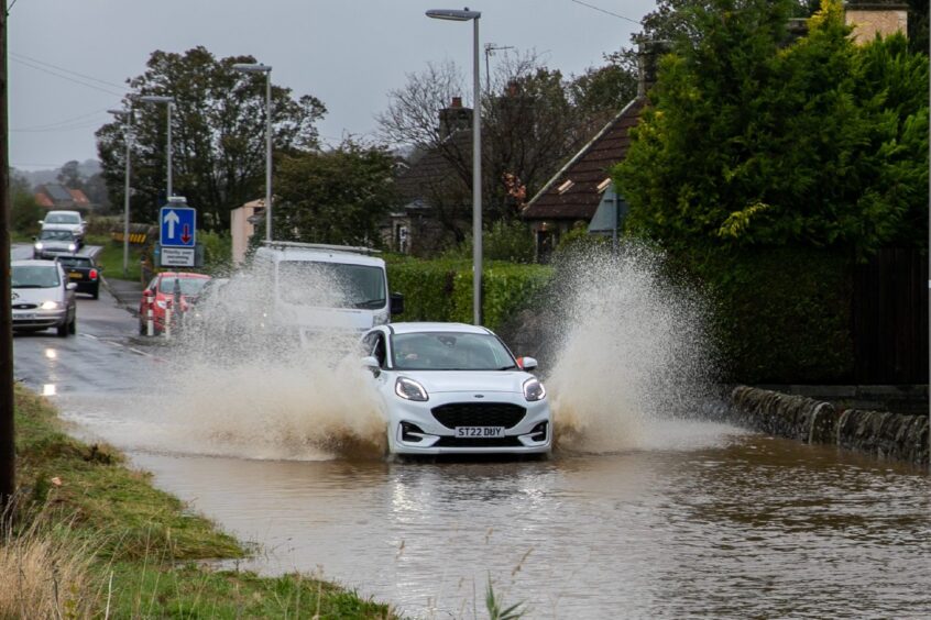 A motorist drives through flood water at speed in Pitscottie.