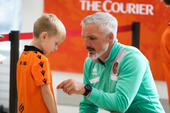 Dundee United boss Jim Goodwin signs a young fan's shirt. Image: Steve Brown/DC Thomson.