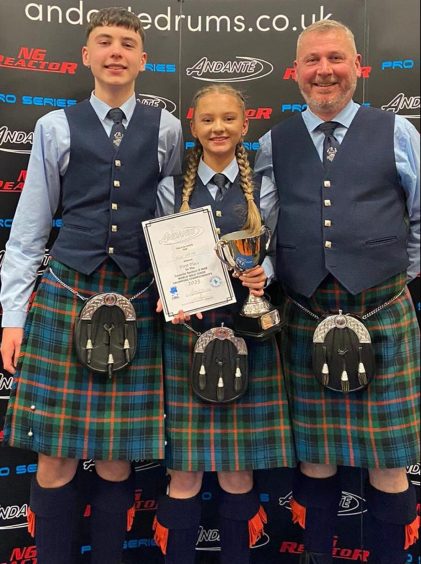 Archie, Flora and Alistair McNab in kilts at pipe band event