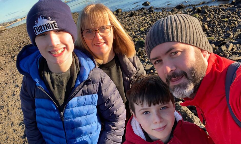 Liam Thomson with his family on a beach.