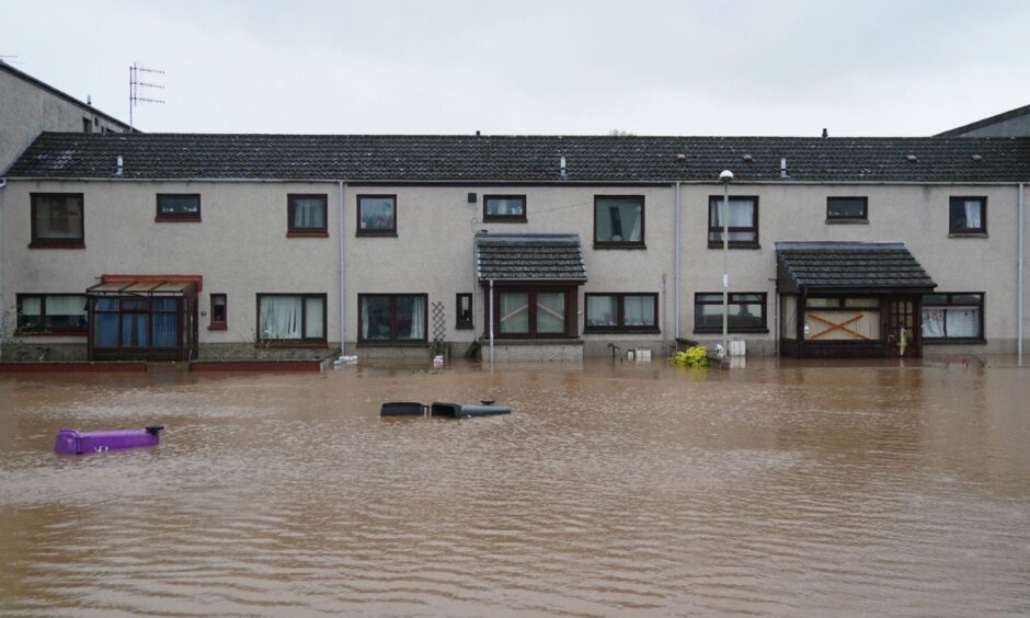 The front of houses in Brechin with floodwater near the windowsills after Storm Babet