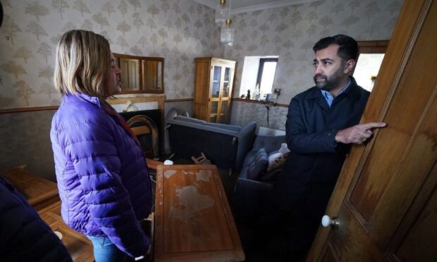 First Minister Humza Yousaf speaks to Kim Clark as he looks at water damage in their house during a visit to Brechin. Image: Andrew Milligan/PA Wire