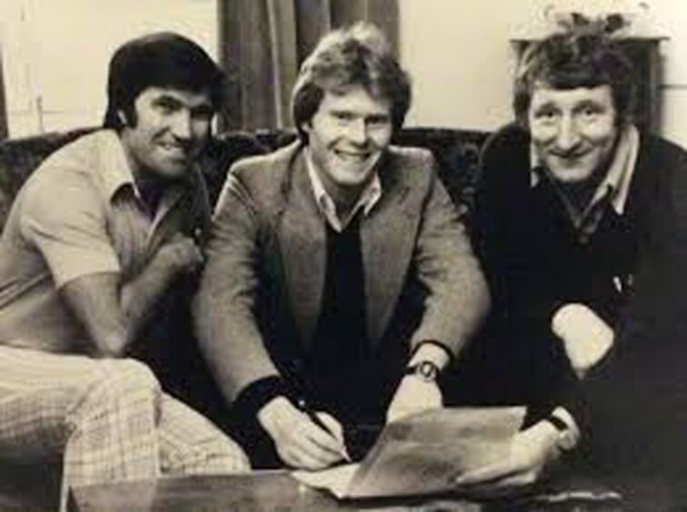 Dave Mackinnon signs his transfer from Dundee to Partick Thistle in Perth's Salutation Hotel flanked by two Lisbon Lions - Jags boss Bertie Auld and Dee manager Tommy Gemmell.