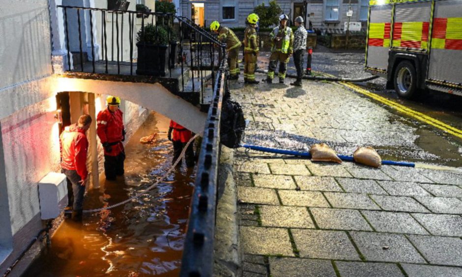 Fire crews at a basement property at Rose Terrace in Perth during the flooding in October 2023. People are standing up to their knees in water
