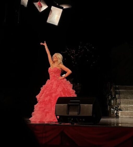Mackenzie Connor in salmon pink ball gown on stage at the beauty pageant in Blackpool