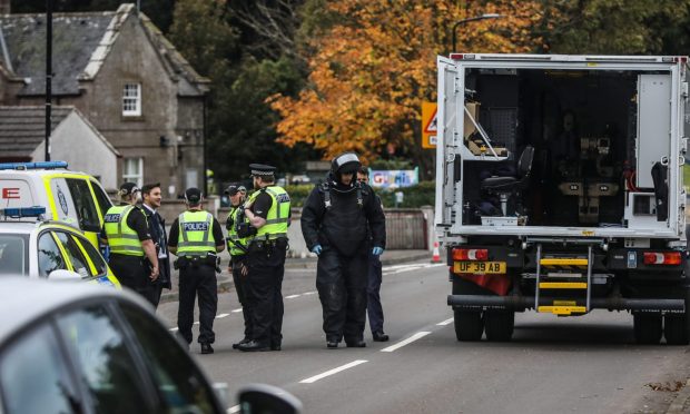 Police officers puts on protection suit in Glamis. Image: Mhairi Edwards/DC Thomson