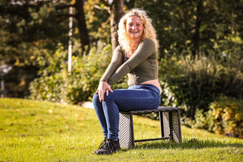 Ruby McDonald sitting on a chair in a garden. 