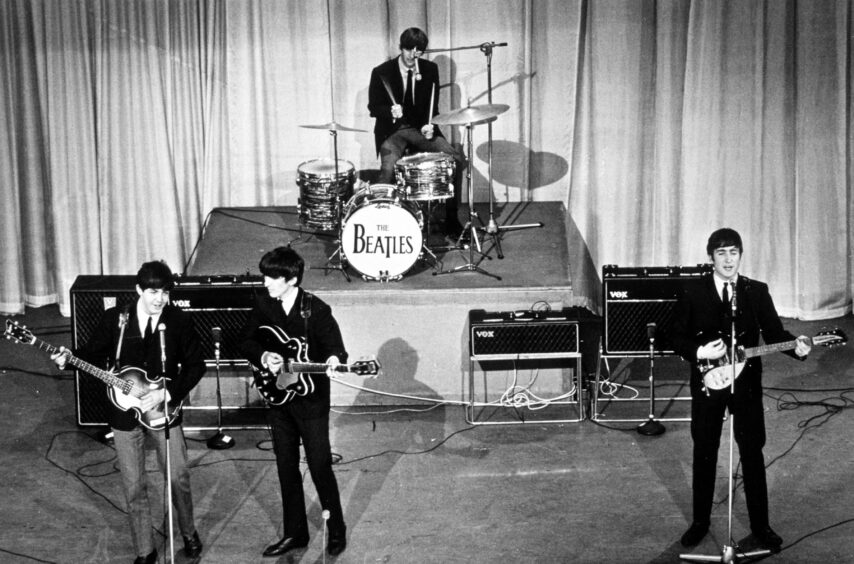 The Beatles performing on stage.