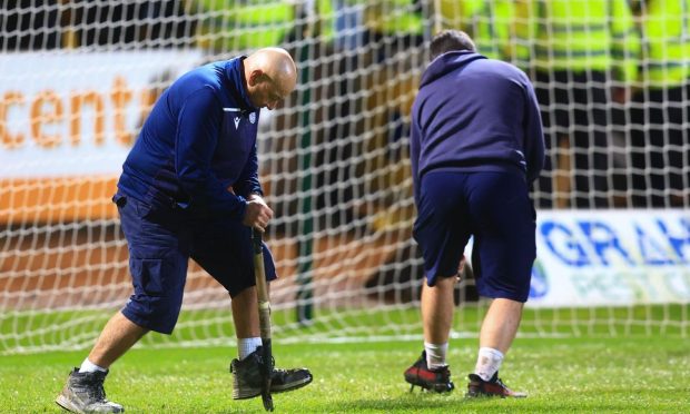 Groundsmen Brian and Brian Robertson work on the Dundee pitch. Image: Shutterstock