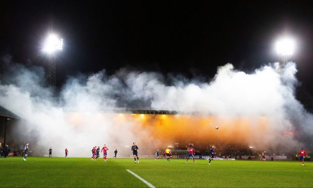 Dens Park was filled with smoke during the game. Image: Shutterstock