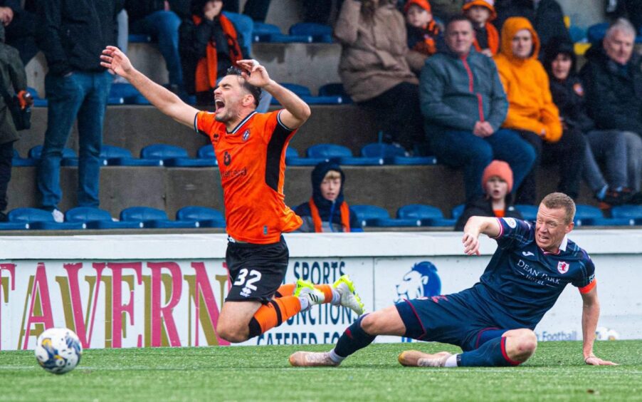 Raith Rovers skipper Scott Brown lies on the ground as his challenge for the ball sends Dundee United striker Tony Watt flying with his arms in the air.