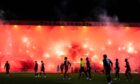 Rangers fans set off flares as the match eventually kicked off, delaying things once more. Image: SNS