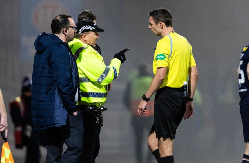 Police officers speak with referee Kevin Clancy