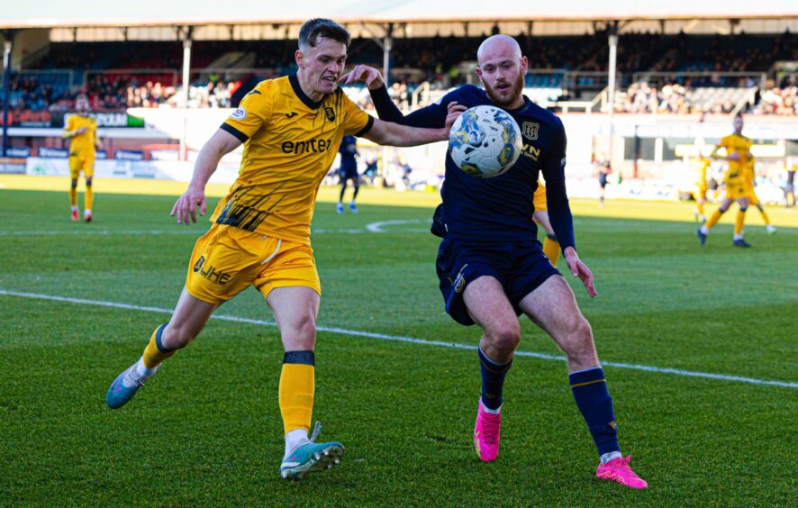 Dundee's Zak Rudden battles for the ball with Livingston defender James Penrice.