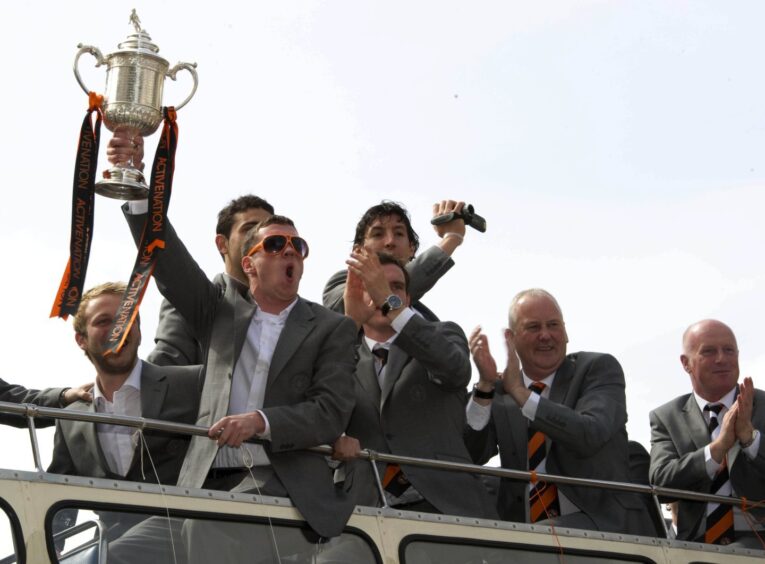 Danny Swanson, holding the trophy, laps up the open-top bus parade in 2010