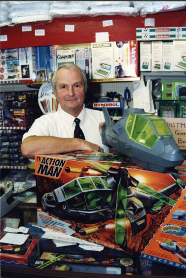 Image shows an old photograph of Nappy Pin and Toymaster owner Alex Stewart in his Cupar store.