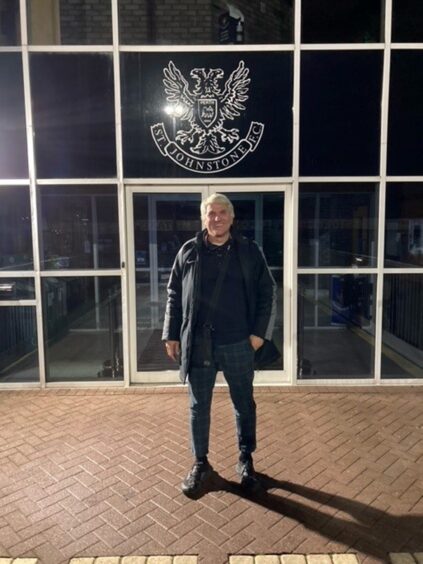 Attila Sekerlioglu outside McDiarmid Park with the St Johnstone club crest on the glass door behind him.