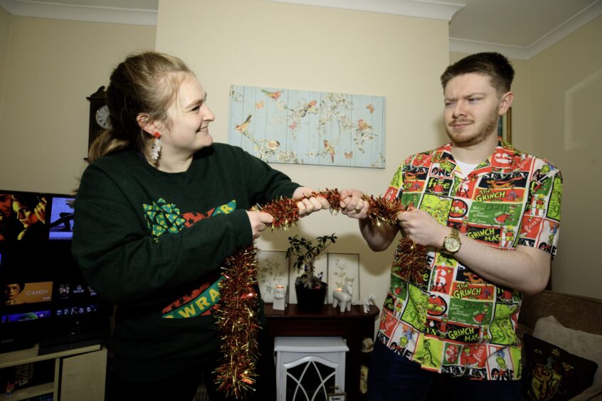 Becky, left, and John, right, fight over a piece of red tinsel.
