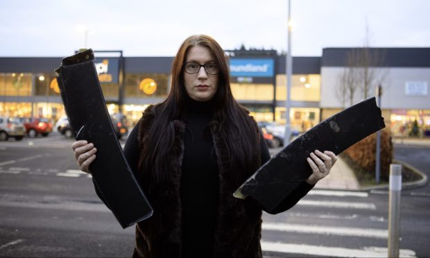 Louise Paterson holding parts of her car's bumper