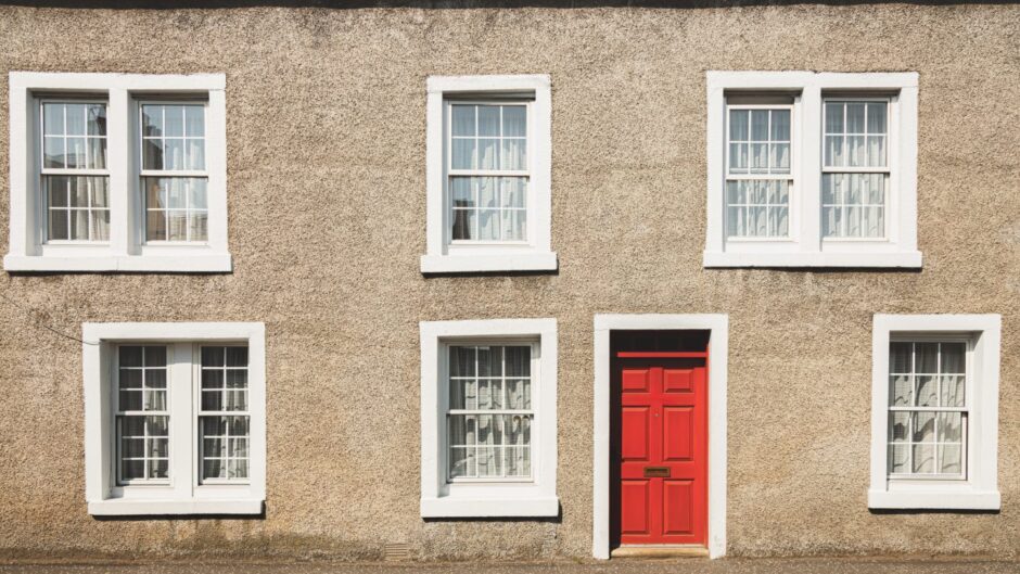 Front of flats with red door.