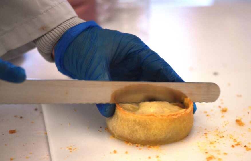 Cutting into a Scotch pie at the world championship judging day