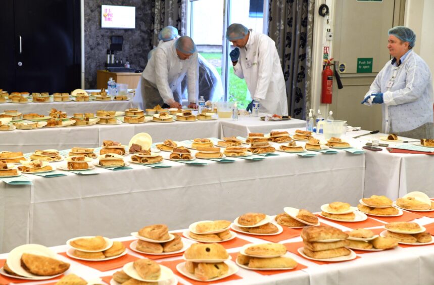 Four tables full of pies being judged at the World Championship Scotch Pie Awards