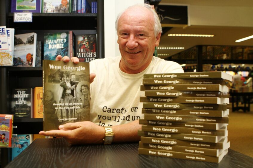Image shows author George Burton with a pile of copies of his first book Wee Georgie.