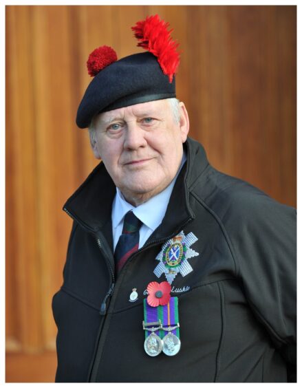 Black Watch veteran George McLuskie wearing his feathered hat and medals, and a red poppy on his jacket.