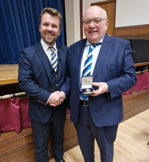 Forfar Athletic legend David McGregor receiving a SPFL long service medal from the SPFL’s chief operating officer Calum Beattie