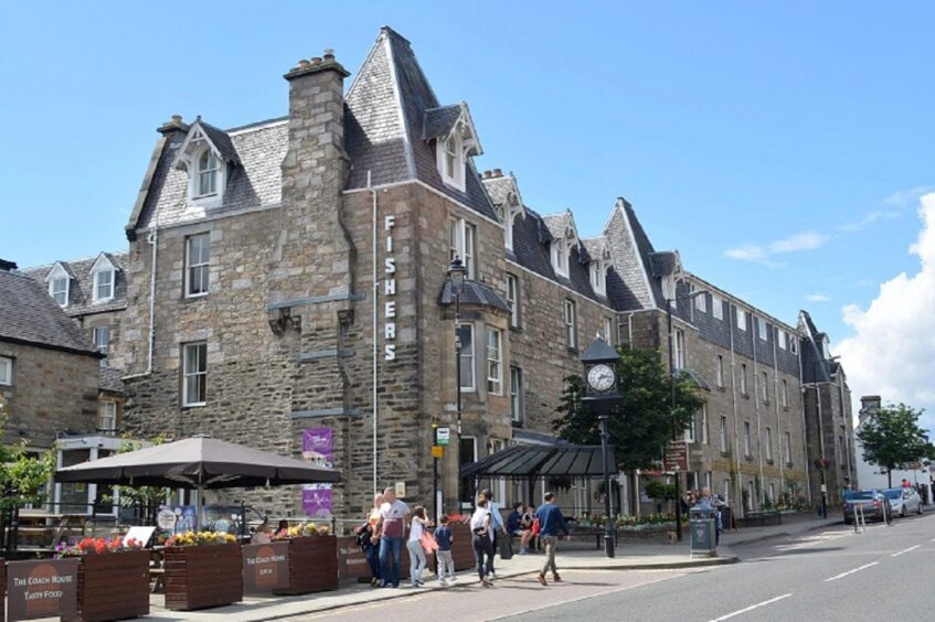 Fisher's Hotel on Pitlochry main street on a sunny summer day with visitors walking past