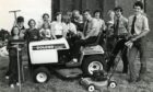 Scouts and helpers cut the grass at Mid Craigie Parish Church in 1983, after bride and groom-to-be Jean Innes and David Barclay complained about having to have photos taken in the long grass. Image: DC Thomson.