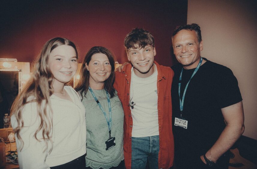 Zoe, Vicky, Ben and Colin Walker stand backstage at a gig.