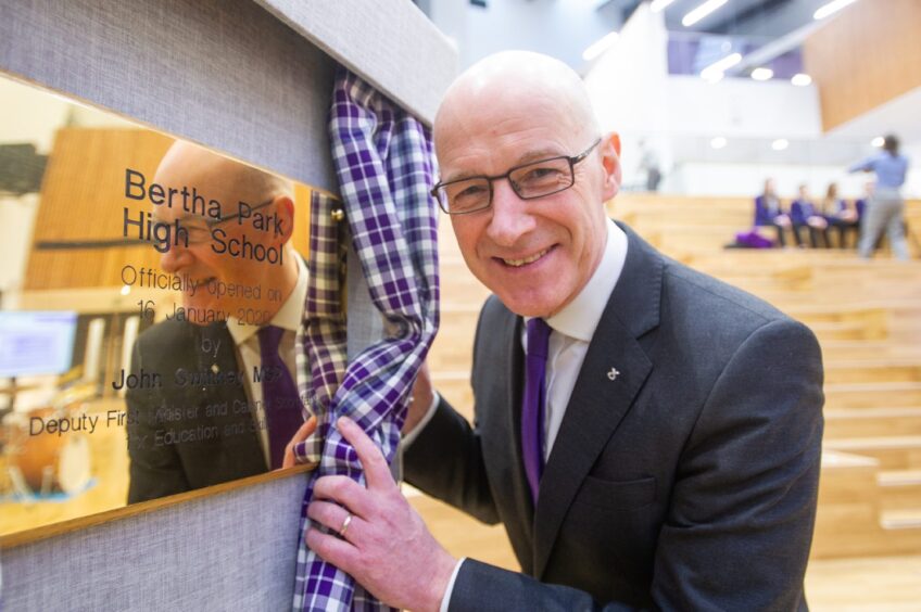 John Swinney MSP next to a plaque commemorating the opening of Bertha Park High School in 2020.