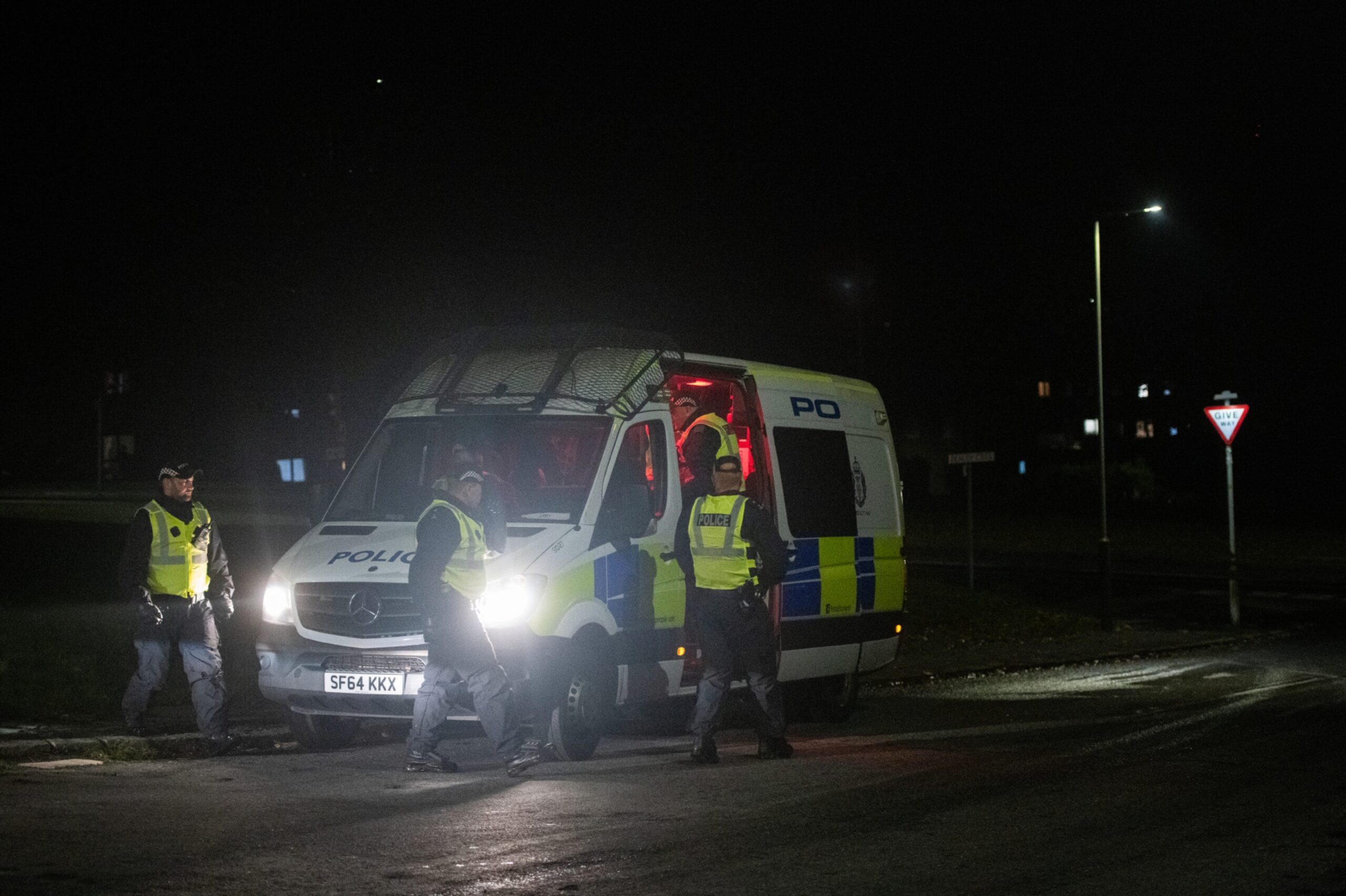 Police entering a police van in Kirkton