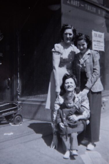 Image shows: an old black and white photograph of Lena Shachman, Bill Shackman's great-grandmother. Lena is standing at the back of the picture with two women and a young child in front of her. 