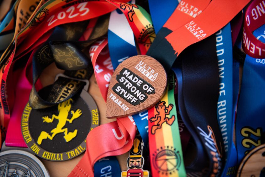 Close up of a large collection of running medals belonging to Lesley Richardson