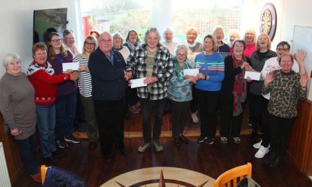 The fundraising group hand over cheques to representatives of the four charities. Image: Wallace Ferrier