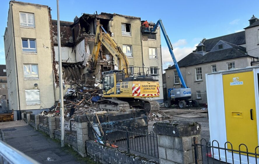 A mechanical grabber tears down the first walls of the Francis Street flats in Lochgelly.
