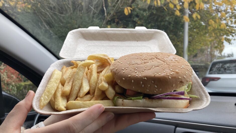 A takeaway box of Vegana vegan burger and chips