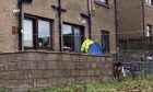 Police have been guarding a small, blue tent in the garden on Brownhill Road. Image: Kieran Webster/DC Thomson