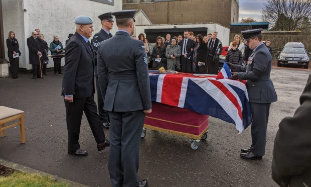 Widow Anne Allan surrounded by her family as the military pay tribute at the funeral of Alastair Allan