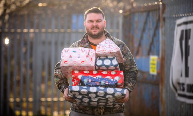 Jamie McAllister holding a pile of presents.