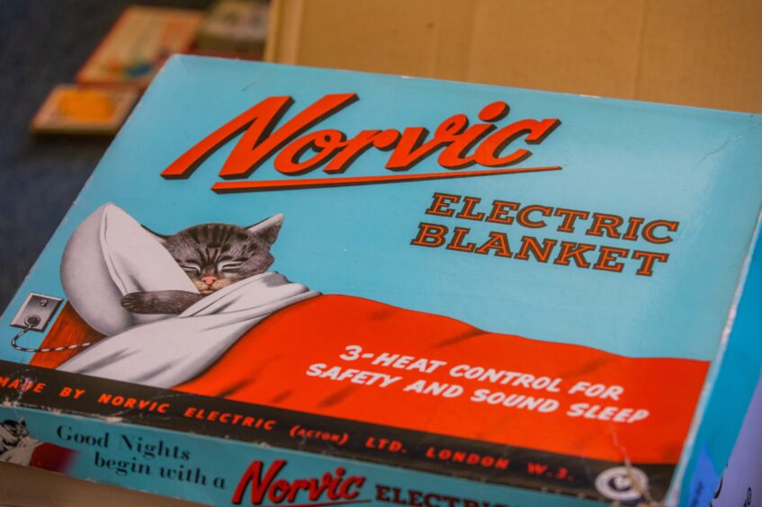 1950s-style box for an electric blanket showing a kitten sleeping in a bed.