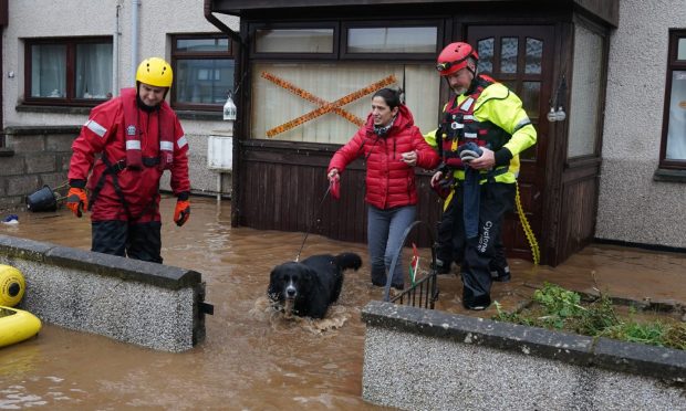 Emergency services helping Laura and her dog escape her house.