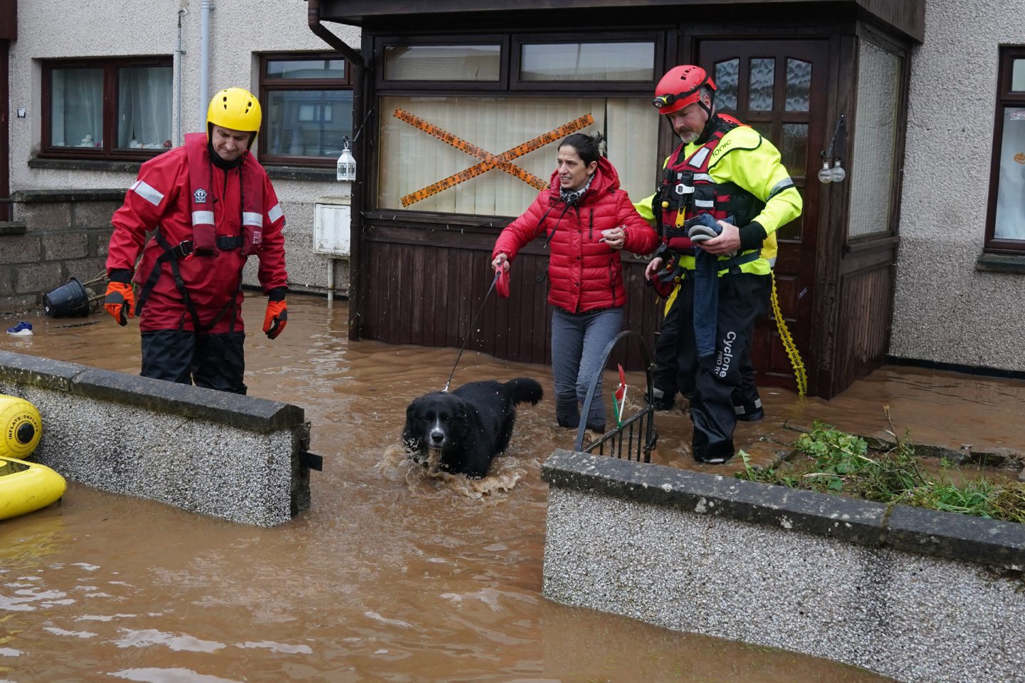 Emergency services helping Laura and her dog escape her house.