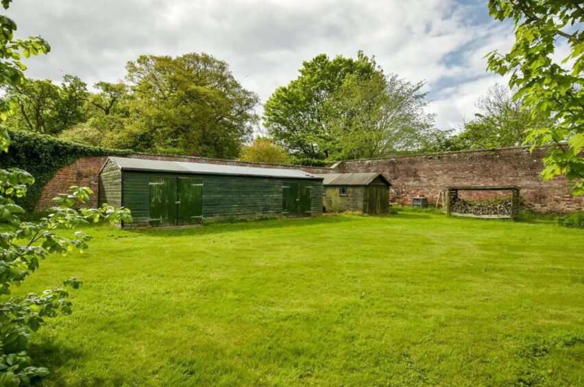 Large timber garden sheds sit to the rear of the house Fife home