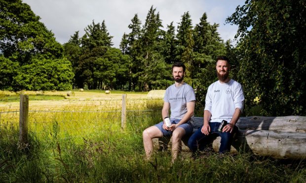 Left to right: Conall and Jack Low seated next to open field.