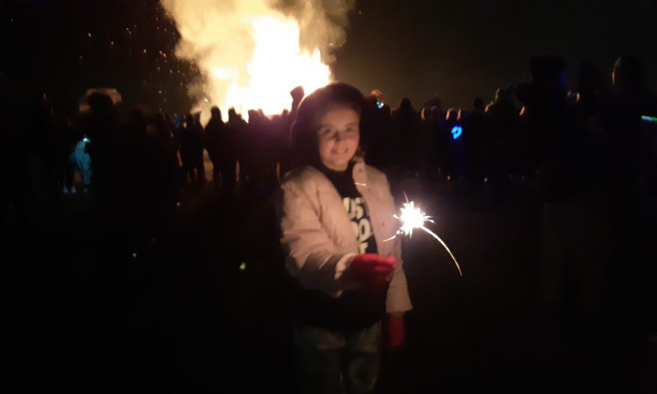 A little girl shows off her sparkler skills.